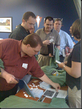 People pick up shirts, pins and MCITP upgrade path papers